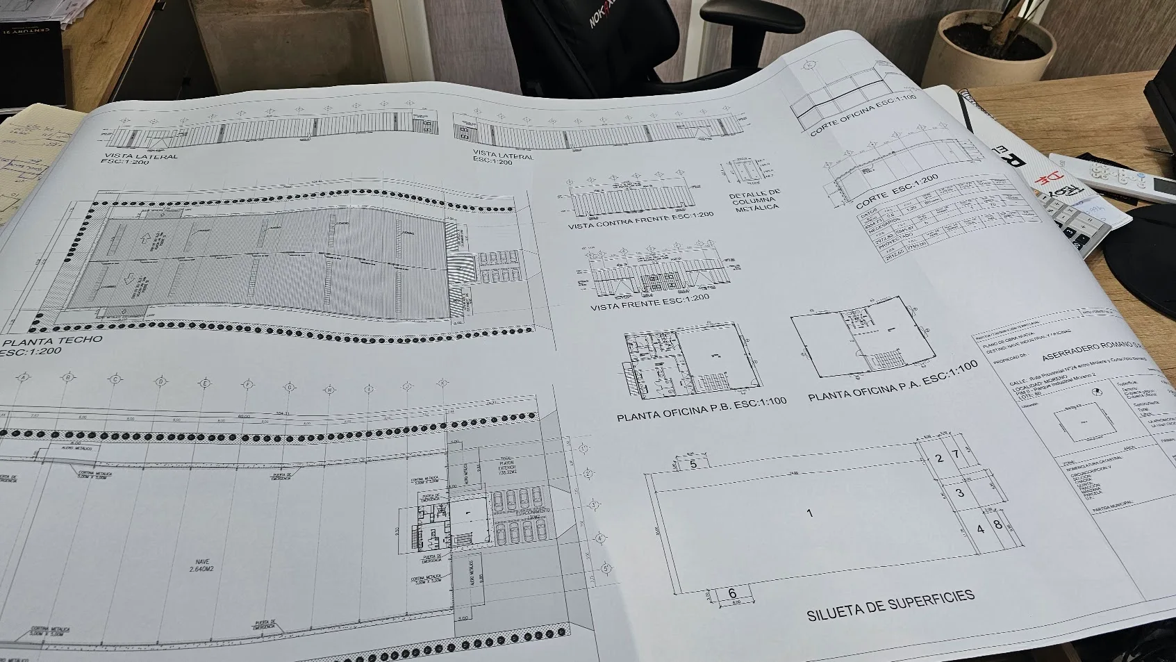 Documentación de arquitectura industrial, plantas y vistas sobre la mesa de trabajo