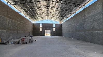 Interior del galpón durante la obra, con estructura de cubierta visible.