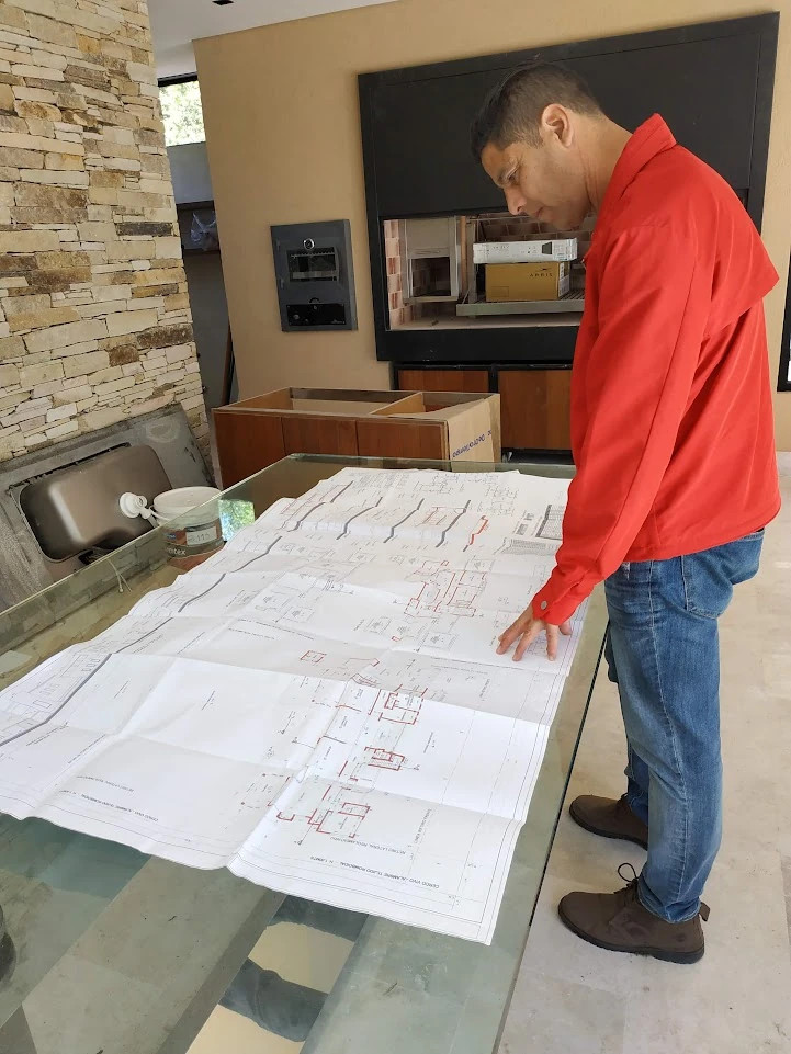 Revisión de planos sobre una mesa durante una visita de obra.